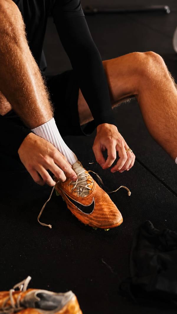 Speler maakt voetbalschoenen klaar voor de sessie